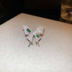 Close-up of a butterfly ring with silver plating, green crystals and pavé cubic zirconia