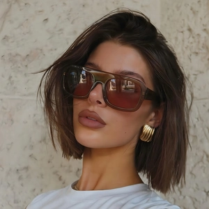 Detail of stylish pilot sunglasses with translucent brown frames on a female model