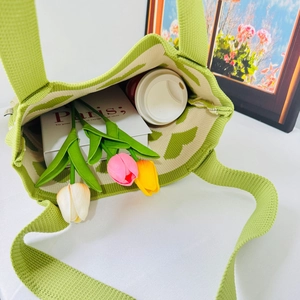 Top-down view of a light green knitted heart tote bag showing interior space and soft texture