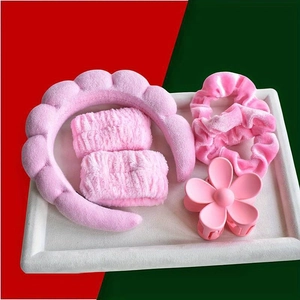 Ensemble bandeau en peluche rose avec bracelets et pince fleur sur plateau blanc