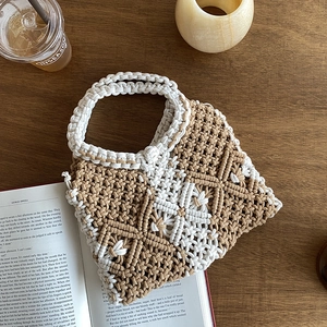 Detailed close-up of bohemian geometric hand-woven cotton rope bag on a wooden surface
