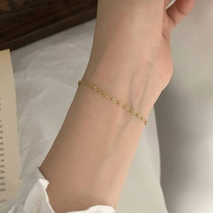 Elegant twisted gold titanium steel thin chain bracelet for women on a model's wrist