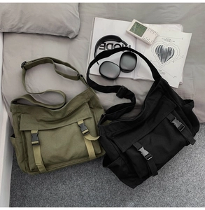 Détail de sacs à bandoulière en toile vert militaire et noir avec des accessoires
