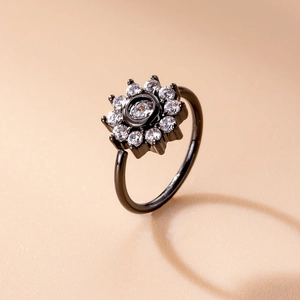 Macro shot of black nose ring with sunflower zircon setting on a neutral background