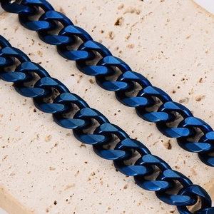 Deep blue stainless steel Cuban link chains on a textured stone surface for a punk style