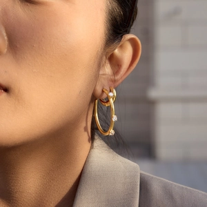 Macro detail of 18K gold plated stainless steel hoop earring with inlaid cubic zirconia
