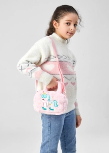 Detailed view of pink plush unicorn crossbody bag with embroidery on child model