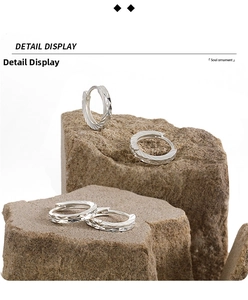 Detail view of S990 sterling silver hoop earrings with faceted geometric textured finish