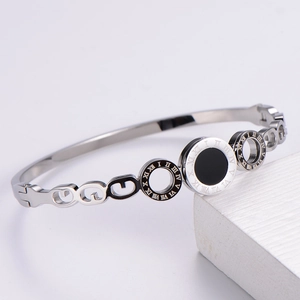 Detailed view of silver stainless steel bangle featuring engraved Roman numerals and chain links