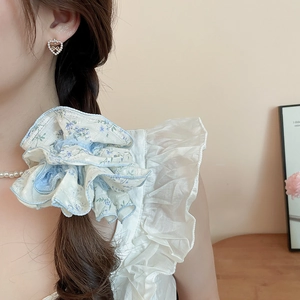 Blue floral lace scrunchie shown on a braided hairstyle for a sweet and elegant look