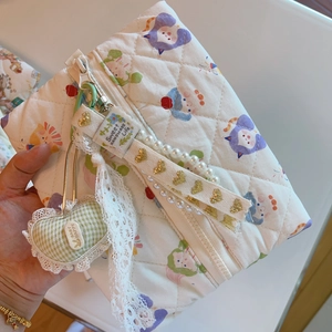 Detailed quilted makeup bag with floral cat patterns, lace trim, and beaded zipper pull