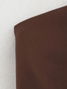 Close-up detail of the brown fabric texture and material of the vintage suit set