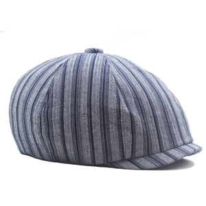 Side view of vintage blue striped cotton newsboy cap with top button detail