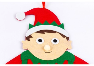 Close-up of a felt Christmas elf ornament head with red and green hat and hanging ribbon