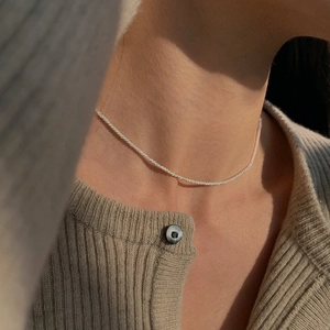 Close-up of sparkling S925 sterling silver chain on neck under natural sunlight