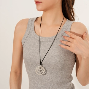 Close-up of triple-layered geometric pendant necklace with crystals on black cord