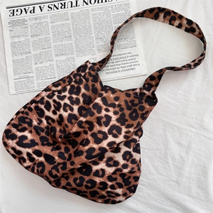 Macro shot of stylish leopard print canvas tote bag with wide strap on magazine background