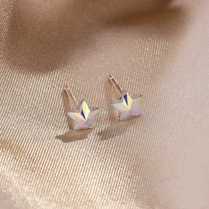 925 silver star earrings with iridescent crystal facets on champagne satin background
