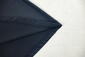 Close-up of fine double-needle stitching on the hem of a sleek black bodycon dress