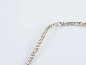 Detailed macro view of dense sparkling rhinestones on an elegant silver dress strap