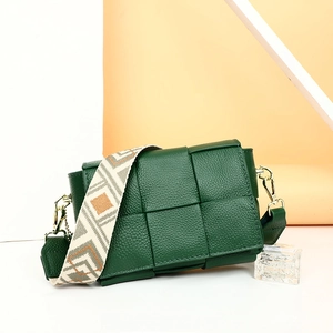 Detailed view of green woven leather square bag with geometric patterned wide strap