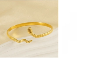 Detailed view of 18k gold plated snake-shaped open bangle with textured lattice pattern