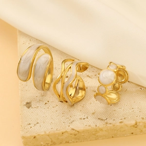 Three irregular liquid gold stainless steel rings with white marble enamel inlay