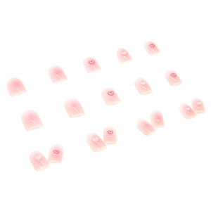 Short pink ombre press-on nails with red and white heart designs in a complete set