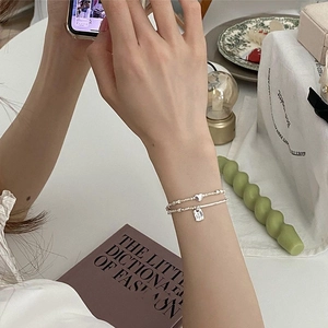 Minimalist sterling silver bracelet set with heart and square charms on double beaded chains
