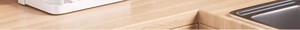 Close-up of a pot lid holder on a wooden countertop near a stainless steel kitchen sink