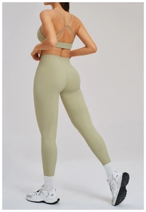 Dettaglio del reggiseno yoga incrociato e leggings a vita alta nel set fitness salvia