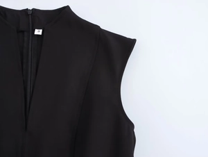 Detail view of the black sleeveless mini dress with invisible zipper and size S label