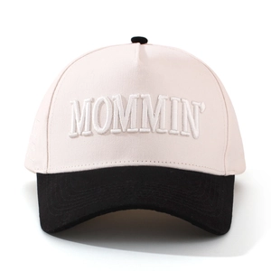 Dettaglio del ricamo 3D MOMMIN su cappellino da baseball bicolore rosa e nero