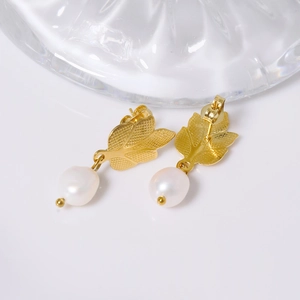 Elegant gold leaf earrings with white freshwater pearls shown on clean white background