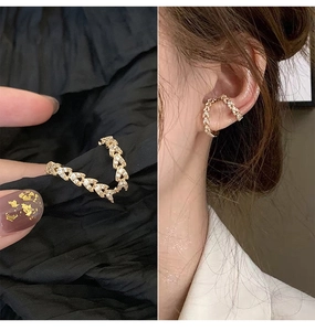 Detailed view of 14k gold leaf ear cuff with sparkling zircons and model wearing style