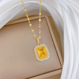 Détail d'un pendentif en zircon jaune carré en acier titane doré sur boîte à bijoux