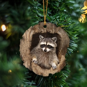 Detailed view of 2D acrylic raccoon Christmas tree ornament with festive pine background