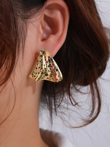 Macro shot of 18K gold plated earrings with colorful rhinestones and wrinkled texture