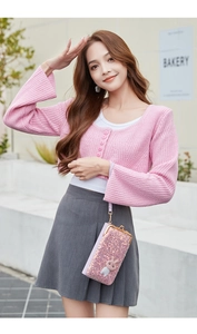 Pink sequin crossbody wallet bag styled with a pink cardigan in a sunny bakery setting