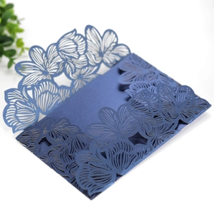 Detail of dark blue laser-cut floral invitation with intricate pearlescent paper texture