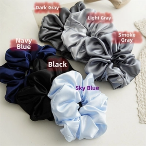 Detail of assorted satin scrunchies in gray, navy, black and blue with silk texture