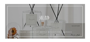 Minimalist reed diffuser with black sticks and square flat glass bottle in home setting