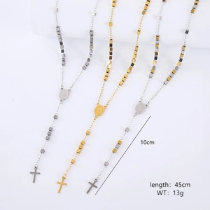 Detail showing gold and silver rosary style necklaces with square beads and cross pendant