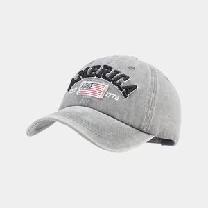 Detailed view of America flag embroidery on washed grey cotton baseball cap