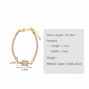 Macro view of adjustable pink woven bracelet with micro-pave turtle pendant in 18k gold