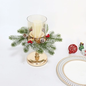 Golden Christmas candle holder with green fir branches, pine cones and red berries decor