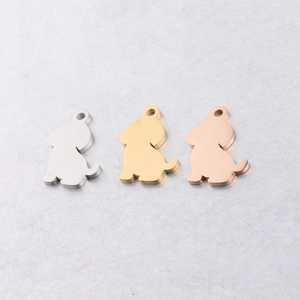 Detailed macro view of three puppy-shaped stainless steel pendants in silver, gold, and rose gold