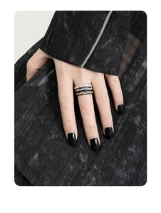 Detailed view of layered wavy textured s925 silver rings in gold, silver and black finishes