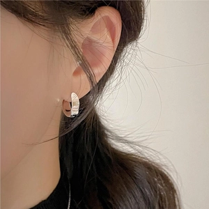 Minimalist 925 sterling silver hoop earrings with irregular hammered texture on model