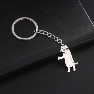 Close-up of a silver stainless steel kitten keychain with a thumbs-up on a black cover